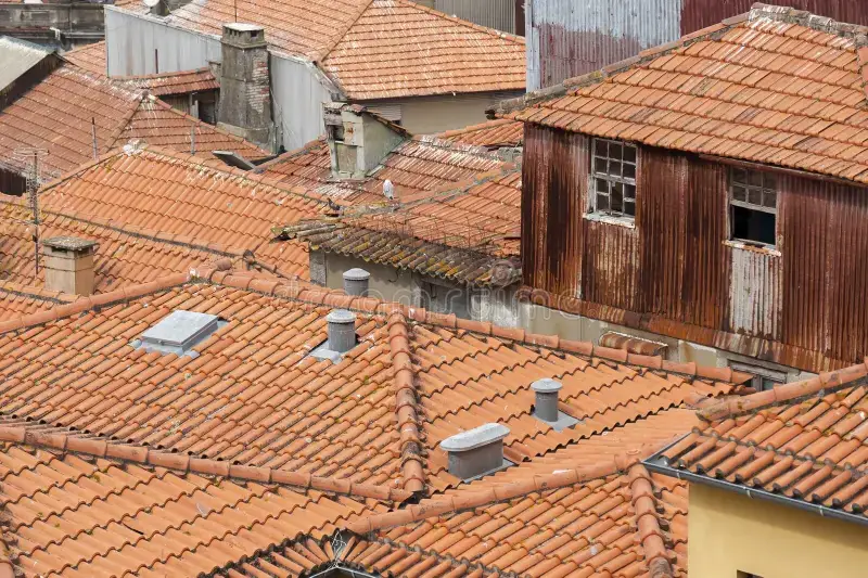 Aerial view of terracotta tiled rooftops in Porto with chimneys
