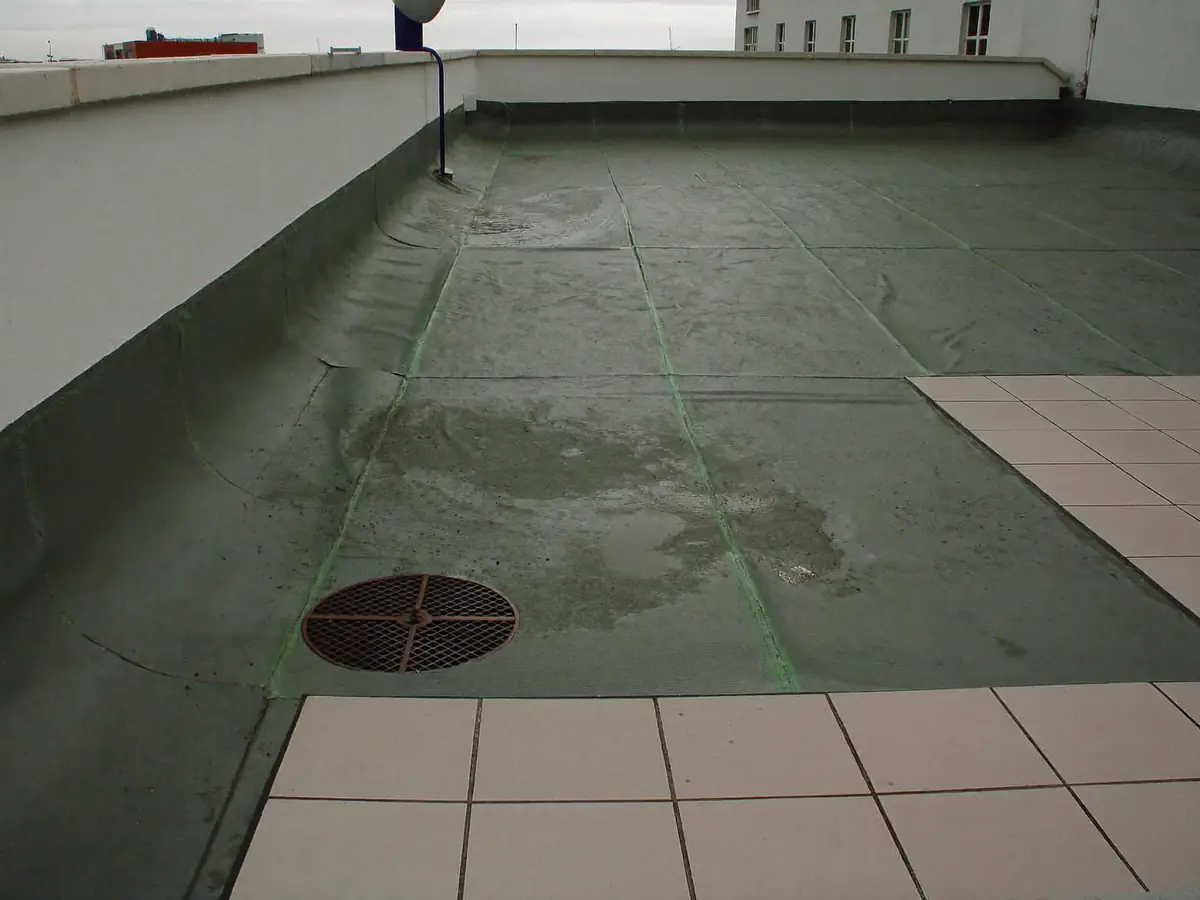 Flat roof terrace with a failing waterproofing membrane and wet patches