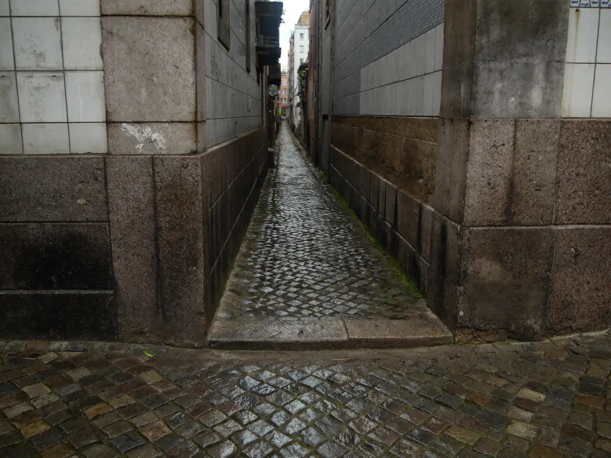 Narrow cobbled alley between old granite houses in Porto’s historic centre