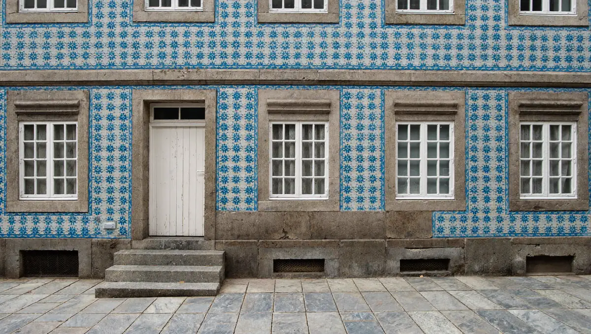 Porto townhouse facade covered in blue azulejo tiles with granite window surrounds