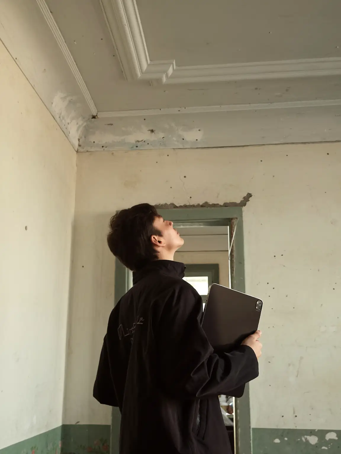 Inspector looking up at the ceiling of an old Porto apartment