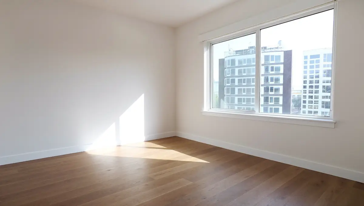 Empty newly built apartment living room with a large window and wooden floor